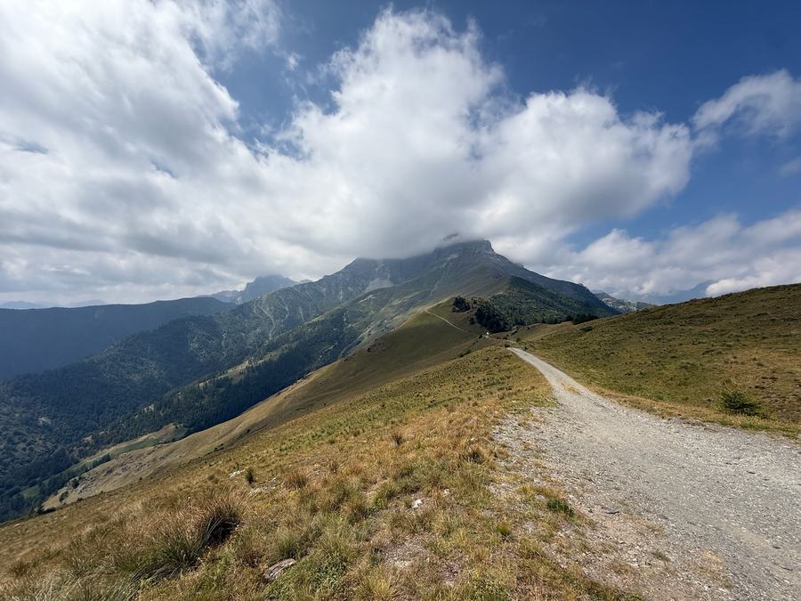 Schotter-Kammstrasse, die auf einen wolkenverhangenen Gipfel zuführt